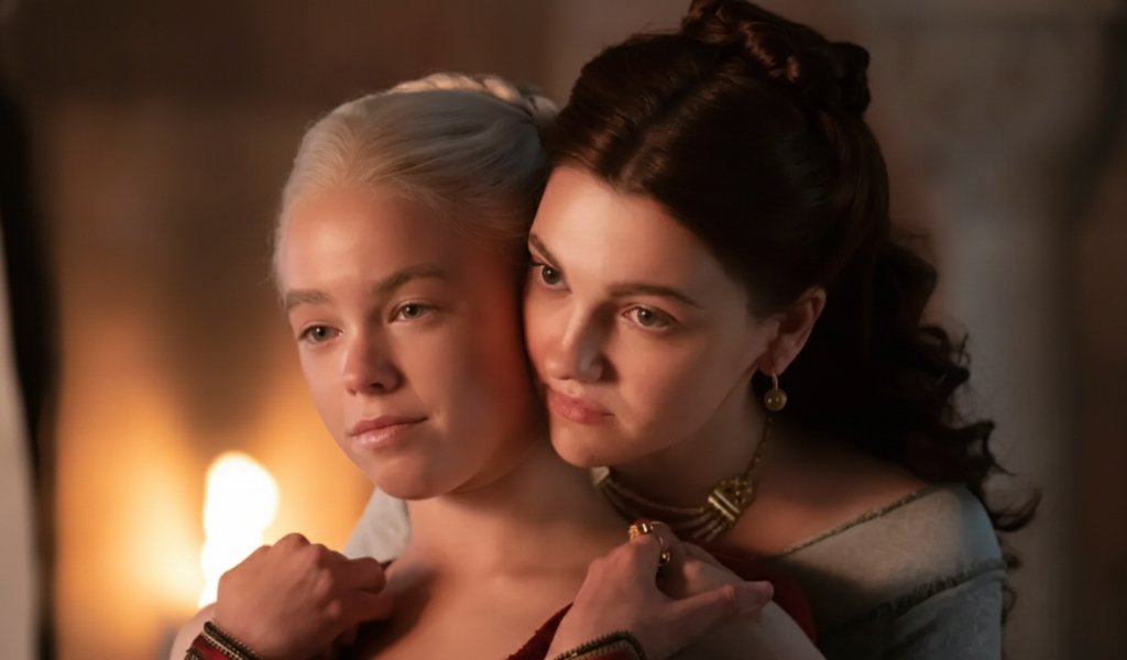 Milly Alcock as young Rhaenyra Targaryen and Emily Carey as young Alicent Hightower sitting together in the Godswood.