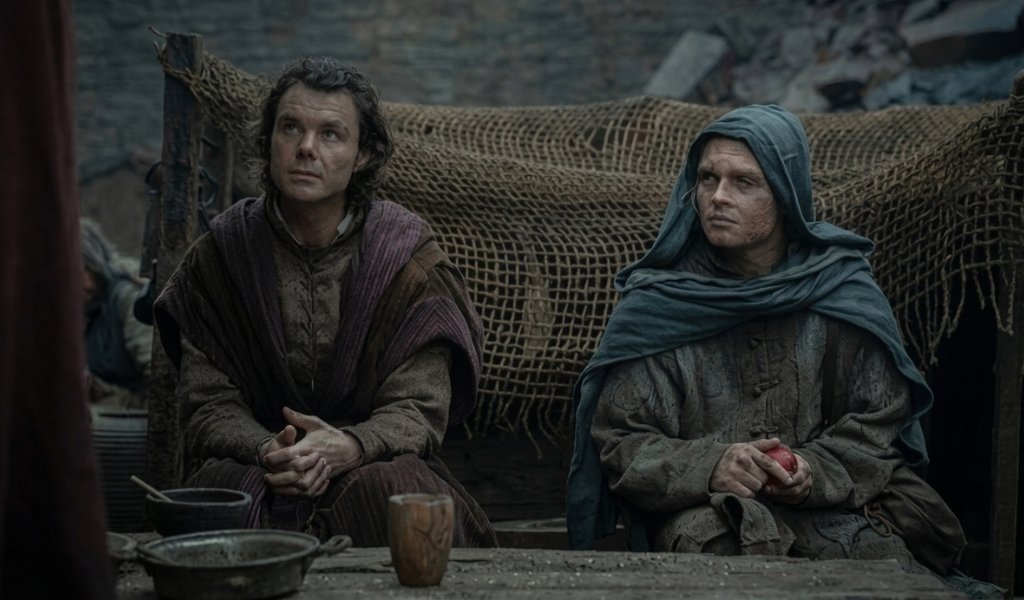King Aegon II holding a scale from Sunfyre next to Larys Strong at Rook's Rest.