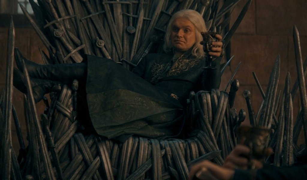 Comparison of Fire and Blood Iron Throne superstition versus House of the Dragon explicit symbolism showing Aegon II lounging on the throne